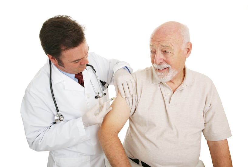 Senior man getting a flu shot from his doctor.