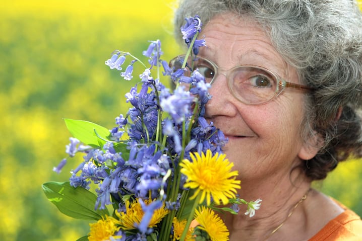 flowers next to face and smiling